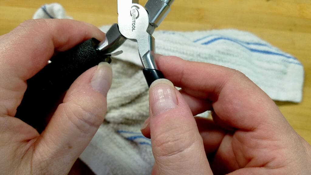 An image showing the comfort grip just below the spring on a pair of jewelry pliers. 
