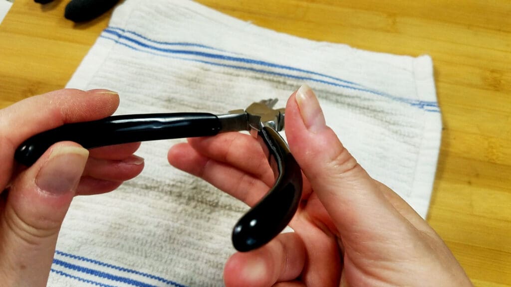 An image showing the author cleaning the handles of a pair of stepped bail-making pliers