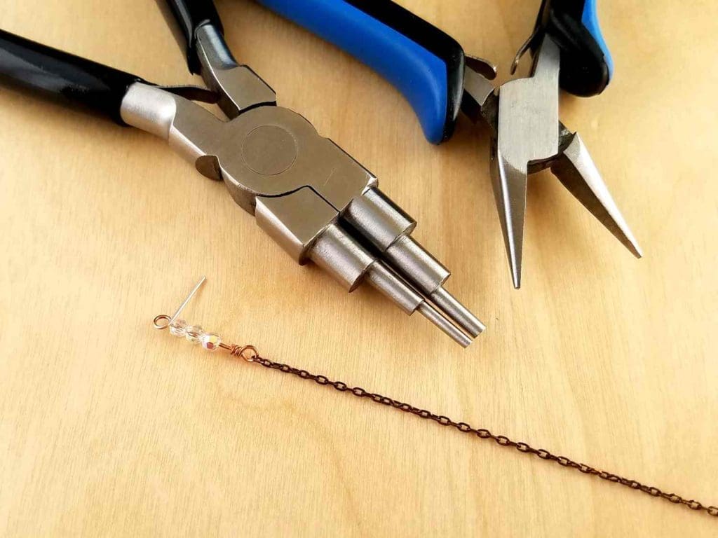 Adding a beaded wrapped loop connector to the end of a piece of chain using stepped bail-making pliers and chain nose pliers