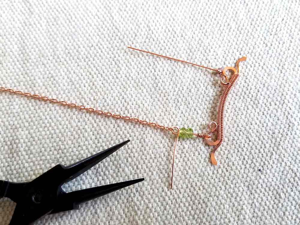 Delicate Bar Pendant, Step 17: Thread accent beads on one wrapped loop and begin a second wrapped loop above the beads. Thread one end of a piece of chain onto that loop