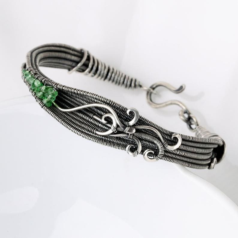 The Lillium bracelet in sterling silver and fine silver and featuring Tsavorite gemstone beads. Designed and fabricated by Sarah Thompson of Sarah-n-Dippity. This design is also a project featured in Sarah's second book, Woven in Wire.