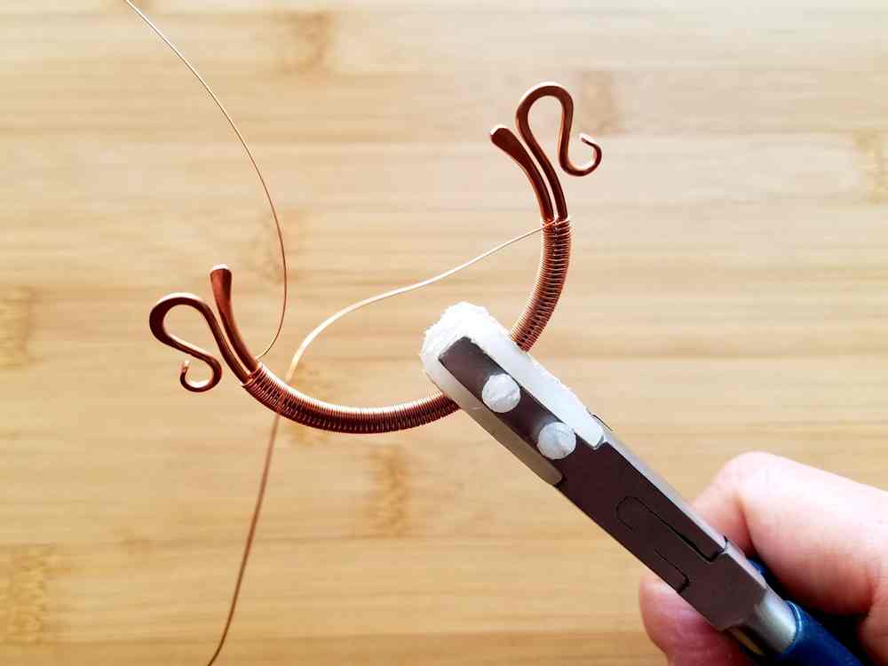 Step 5 - You should have one weaving wire coming out on the front of your bead frame and one wire coming out on the back, as shown here. Double check that the weave aligns with the hole in your focal bead. Make any necessary adjustments to the weave before suspending the beads.