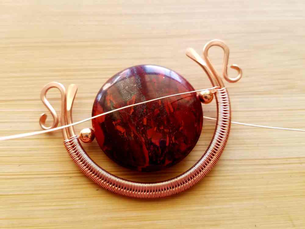 Step 8 - If the holes in your beads will accommodate four passes of weaving wire, complete one weave pattern repeat on each side of the frame, and then feed each end of the wire through the beads again. If your beads will not accommodate four passes of weaving wire, go on to the next step.