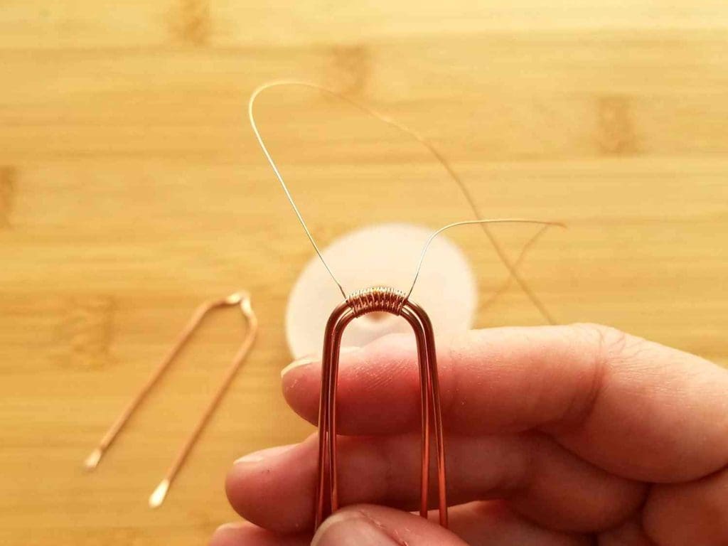 Step 2 - Begin weaving Wires 1 and 2 together at the top of the curve between the two marks indicating the peak on Wire 3