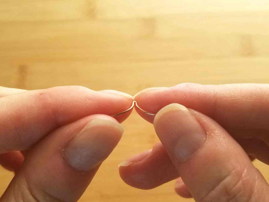 Step 6 - Stretch the folded wire open, making sure that you form even curves on either side of the fold with your fingers, as shown.