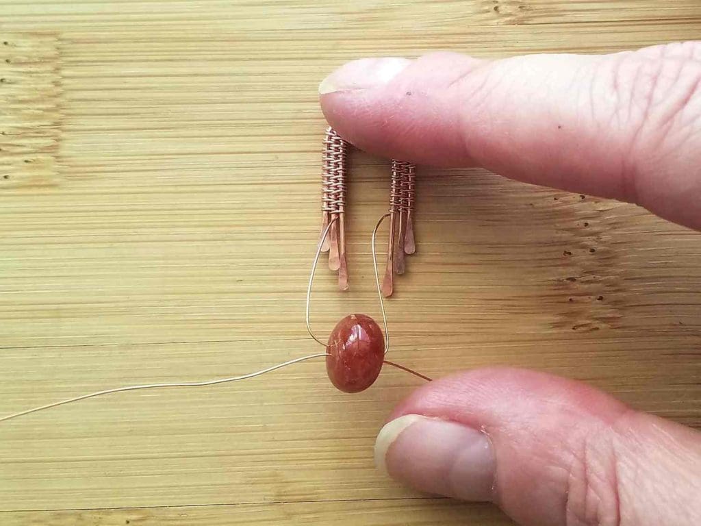 Step 6 - Thread the ends of your weaving wire through your focal bead, one from left to right and the other from right to left, as shown. 