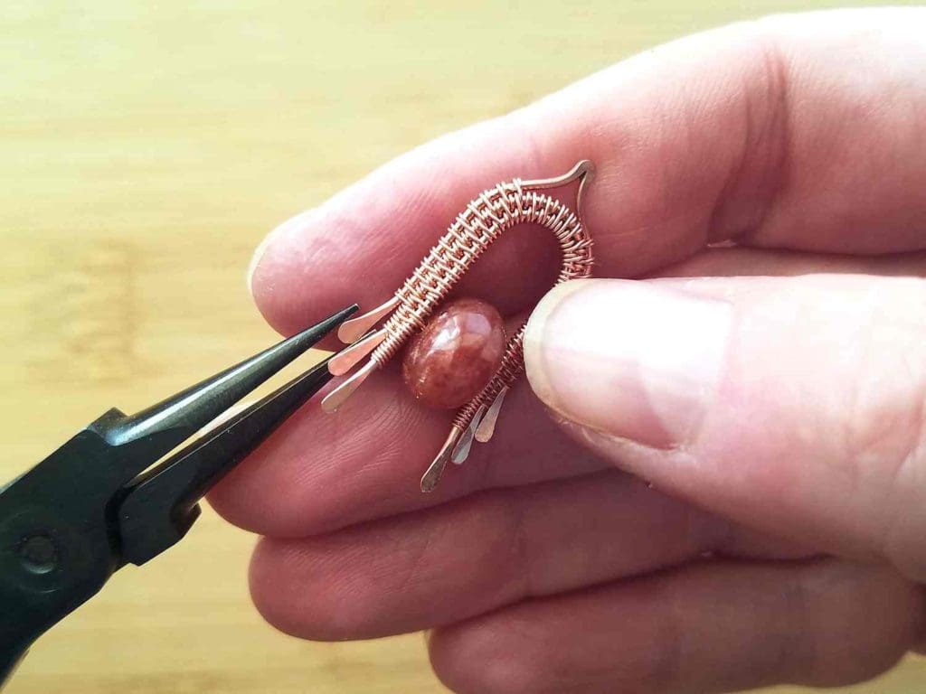 Step 11 - Sculpt your bead frame into a convex curve, as instructed, and use your chain nose pliers to gently flare the ends of your core wires, as shown.