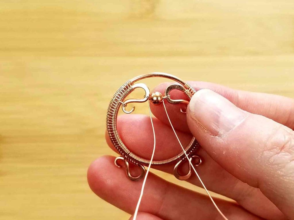 Beads Step 4 - Attach one end of the suspension wire to the remaining end of Wire 1. Then pass that same wire back through the accent bead. You should now have one free end of wire on either side of the accent bead, as shown.