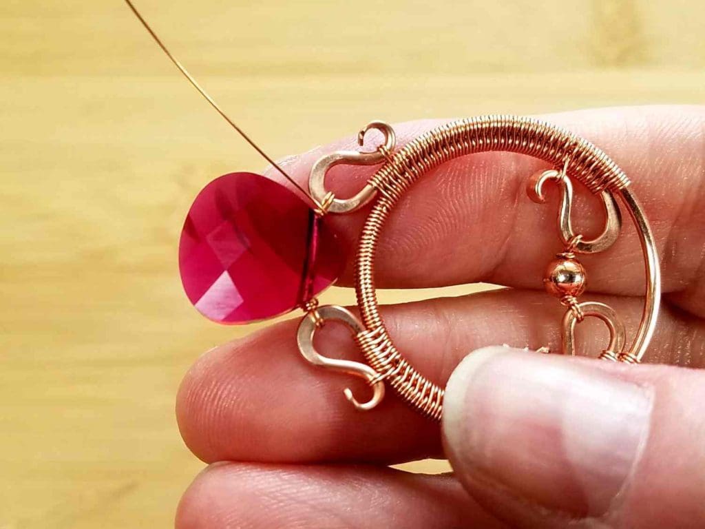 Beads Step 8 - Finish off your focal bead suspension by wrapping the wire tails securely 2 or 3 times. Break the wire tails on the back of the pendant, as shown. 