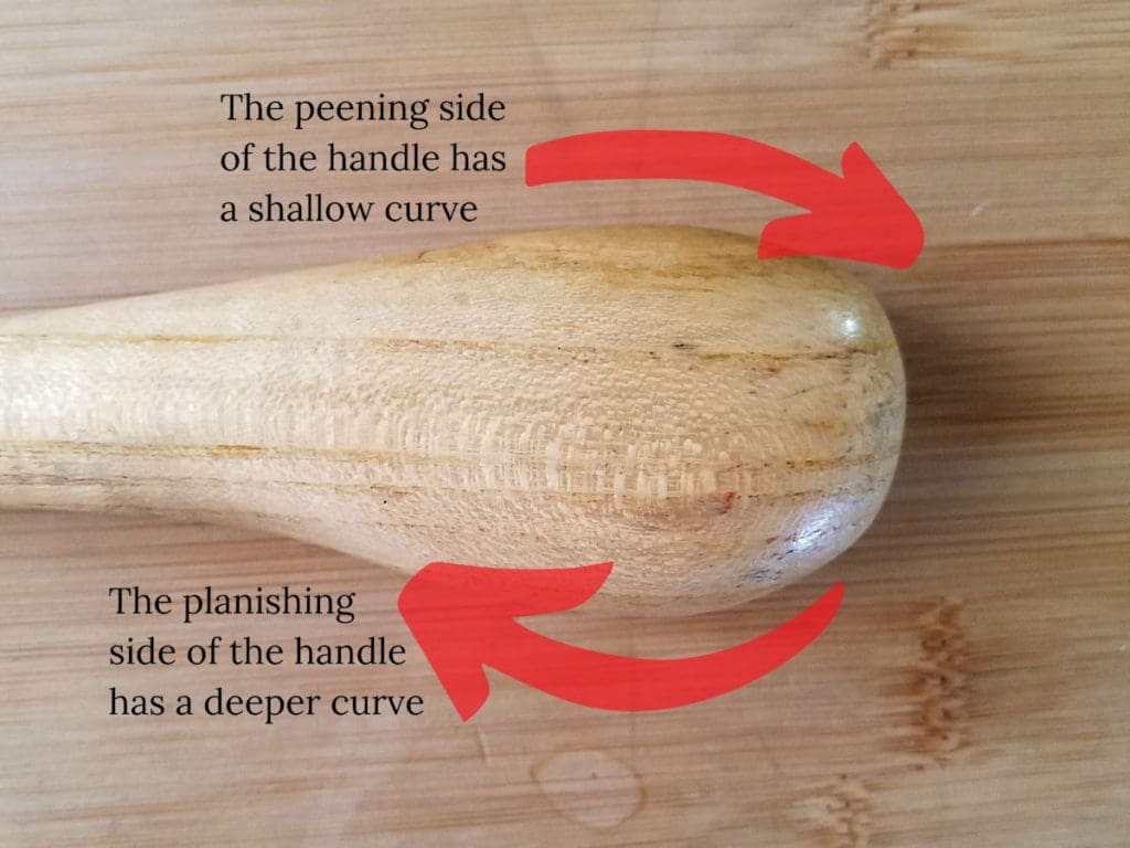 The chasing hammer handle has a distinct shape with a shallow curve on the peening side of the handle and a deeper curve on the planishing side, as shown here.