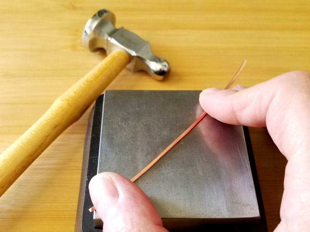 To texture wire, hold the wire steady on your bench block, as shown. Then bounce the peen evenly over the wire.