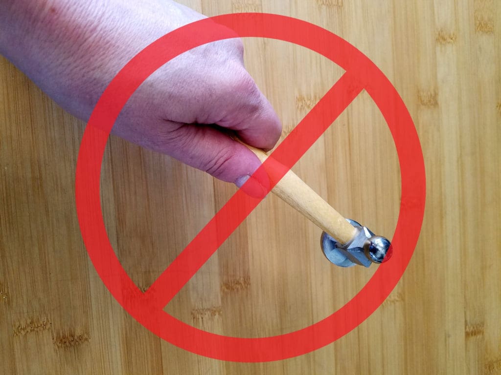 This image shows the wrong way to hold a chasing hammer. This is a common mistake that beginners tend to make. 