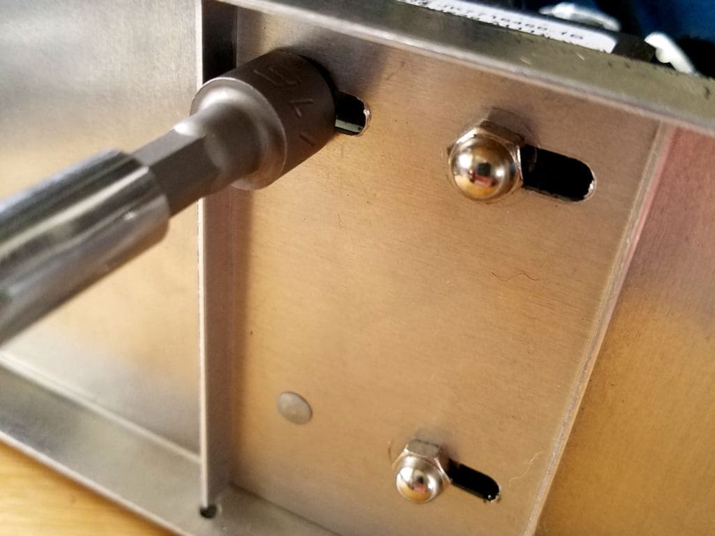 Loosen the three cap nuts that secure the motor to the housing, as shown.