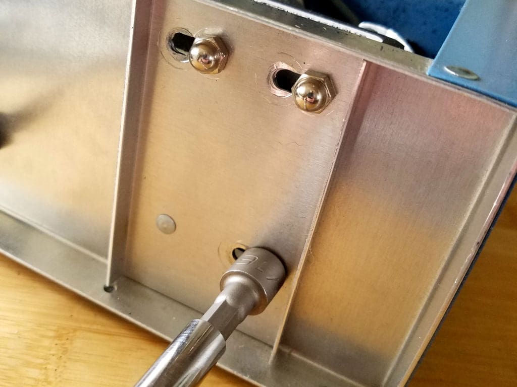 Re-tighten the cap nuts to secure the motor in its new position, as shown.