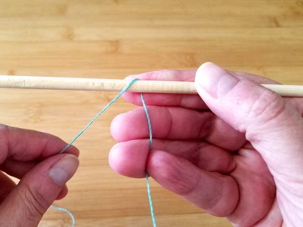 Bring the working end of the weaving wire over and around the front of the first core wires, as shown. 