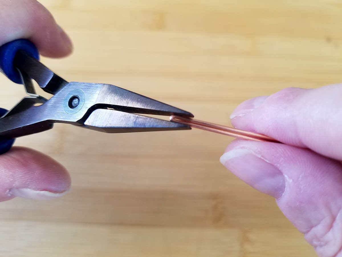 Here the author is pressing the fold tight with flat nose pliers.