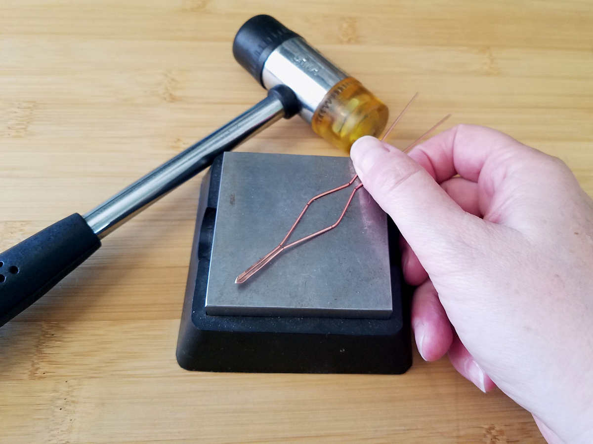 The final step to prepare the bail frame for weaving is to work harden the wire with a bench block and soft mallet, as shown.