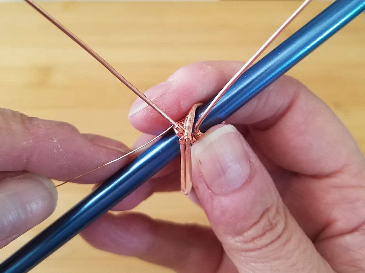 In this image, the author is preparing the central core wire for the bead embellishment. 