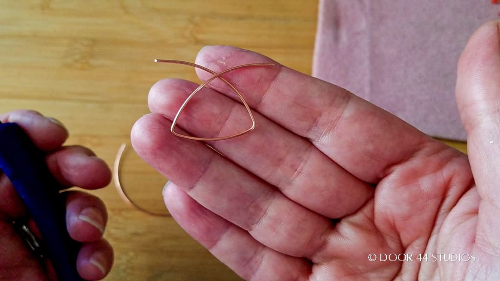 Begin forming the fan shape with flat nose pliers. When finished with the first two bends, the frame should resemble the one pictured here.