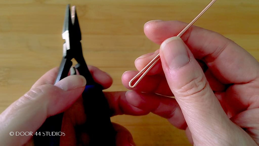Step 1: Fold the wire in half with flat nose pliers, as shown.