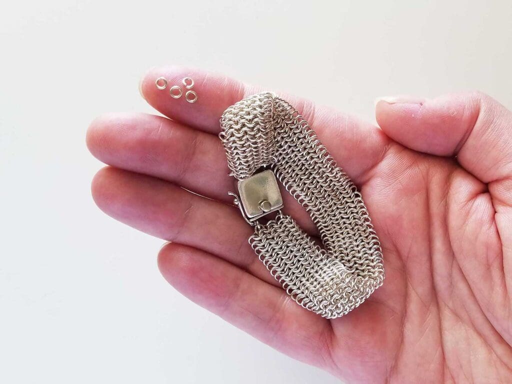 A sterling silver micromaille bracelet woven in the popular European 4-in-1 wave. Pictured in the hand of the author