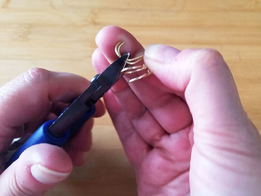 Trimming the ends of the two ear wires evenly with a pair of super flush wire cutters