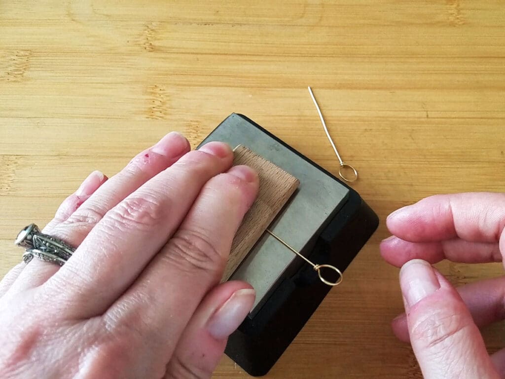 Using a steel bench block and a piece of hardwood to straighten and harden the center core wire