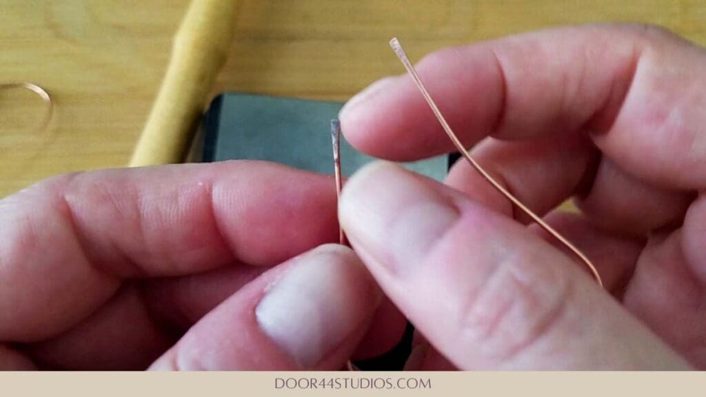 The paddled end of wire that will form the hook on the simple heart hoop earring